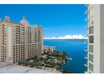 Aerial view of a modern highrise building with a pool and ample parking at 301 Quay Commons # 1111, Sarasota, FL 34236