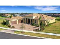 Luxury home with tile roof, three-car garage, and landscaped yard at 4672 Mondrian Ct, Sarasota, FL 34240