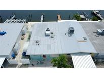 Aerial view of waterfront home with dock access and patio for relaxing and enjoying the coastal breeze at 23 Seaside Ct, Holmes Beach, FL 34217