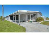 Mobile home exterior with carport and landscaped lawn at 3213 Sumac Ter, Sarasota, FL 34237