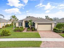 Single-story home with a two-car garage and landscaped front yard at 5384 Layton Dr, Venice, FL 34293