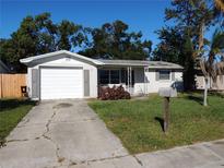 Ranch style home with a single car garage and well-manicured lawn at 3245 Roxbury Dr, Holiday, FL 34691