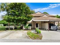 Tan home with a carport, driveway, and mature landscaping, including vibrant green trees at 3415 51St Avenue W Cir # 206, Bradenton, FL 34210