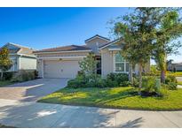 Single-story home with a two-car garage and landscaped lawn at 5628 Long Shore Loop, Sarasota, FL 34238