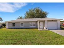 Newly constructed single-story home with a two-car garage and a spacious lawn at 6415 Coliseum Blvd, Port Charlotte, FL 33981