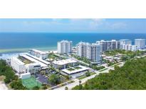 Aerial view of Lido Harbour South community, showing multiple buildings, beachfront, and tennis courts at 2110 Benjamin Franklin Dr # 108, Sarasota, FL 34236