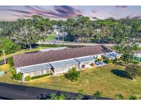 An aerial view shows the home's screened-in lanai, manicured landscaping, and serene outdoor seating at 2431 Golf Course Dr # 703, Sarasota, FL 34234