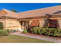 Tan house with orange shutters, a well-manicured lawn, and a paved walkway at 3607 57Th Avenue W Dr, Bradenton, FL 34210