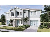 Inviting two-story coastal home showcasing a two-car garage, light blue wood siding, stone accents, and lush landscaping at 5019 Commonwealth Dr, Sarasota, FL 34242