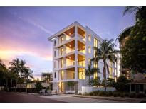 Modern white building with balconies and palm trees, showcasing luxurious design at 509 Golden Gate Pt # 3, Sarasota, FL 34236
