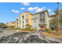 Condo building with two-story units, garages, and lush landscaping at 5601 Bentgrass Dr # 10-112, Sarasota, FL 34235