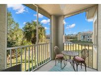Relaxing screened patio with a table set and nature views at 5601 Bentgrass Dr # 10-112, Sarasota, FL 34235