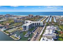 Stunning aerial view of a waterfront condo with marina, tennis courts, and beach access at 5855 Midnight Pass Rd # 511, Sarasota, FL 34242