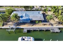 Aerial view of waterfront home with private dock and boat at 834 Jungle Queen Way, Longboat Key, FL 34228