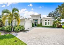 Luxury home with stone accents, metal roof, and paver driveway at 931 Bayshore Rd, Nokomis, FL 34275