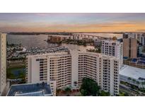 Stunning aerial view of a waterfront condominium complex with boat docks at sunset at 1255 N Gulfstream Ave # 1101, Sarasota, FL 34236