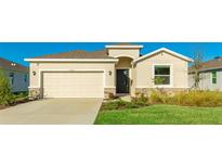 One-story house with beige walls, a tan garage door, and a well-manicured lawn at 15813 6Th E Ave, Bradenton, FL 34212