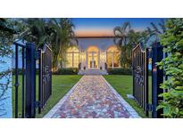 Elegant home exterior showcasing manicured lawn, arched windows, and a mosaic tile walkway at 1682 Hawthorne St, Sarasota, FL 34239