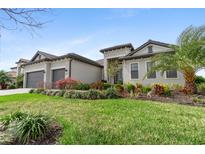 Beautiful single-story home featuring a well-manicured lawn and tropical landscaping at 4906 Lighthouse Bay Ln, Bradenton, FL 34211