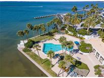 Aerial view of waterfront property with pool, lush landscaping, and boat slips at 888 Boulevard Of The Arts # 1705, Sarasota, FL 34236