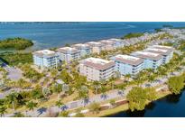 Aerial view of a waterfront community with multiple buildings, lush landscaping, and a scenic waterway at 396 Aruba Cir # 103, Bradenton, FL 34209