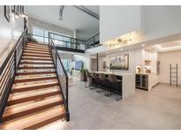 Open living area with modern kitchen island, staircase, and loft at 1990 Main St # Ph 6, Sarasota, FL 34236