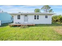 Cute one-story home with a wood deck and a well-maintained lawn at 208 36Th W St, Bradenton, FL 34205