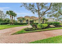 Stunning home featuring lush landscaping, a brick driveway, and a barrel tile roof at 3408 Founders Club Dr, Sarasota, FL 34240