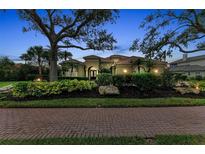 Stunning exterior of the home showcasing lush landscaping and a clay tile roof at 3408 Founders Club Dr, Sarasota, FL 34240