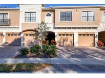 Front view of a tan colored townhome with three garage doors at 4207 Overture Cir, Bradenton, FL 34209
