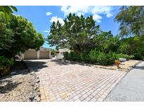 Bright and charming home with a large, paved driveway and lush landscaping at 530 Freeling Dr, Sarasota, FL 34242