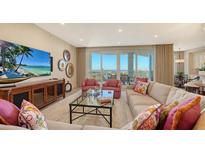 Bright living room featuring a large sectional couch, pink chairs, and floor-to-ceiling windows with lovely ocean views at 2050 Benjamin Franklin Dr # B904, Sarasota, FL 34236