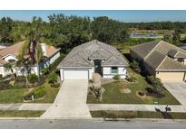 Single-story home with tile roof, attached garage, and landscaped yard at 2316 Harrier Way, Nokomis, FL 34275