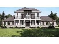 Two-story home with gray roof, white siding, stone accents, and a balcony at 32206 Grand National Drive, Myakka City, FL 34251