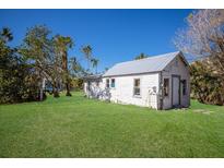 Small cottage with a metal roof and a large grassy backyard at 4420 119Th W St, Cortez, FL 34215
