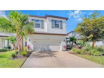 Charming two-story home with lush landscaping, palm trees and an attached two car garage at 5548 Summit Gln, Bradenton, FL 34203