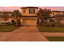 Two-story home with a two-car garage, beautiful landscaping, and a sunset sky at 5548 Summit Gln, Bradenton, FL 34203