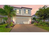 Charming two-story home showcasing a well-manicured lawn, lush landscaping, and a spacious two-car garage at 5548 Summit Gln, Bradenton, FL 34203