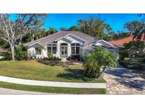 Single-story home with tile roof, light beige exterior, and lush landscaping at 6615 Hunter Combe Xing, University Park, FL 34201
