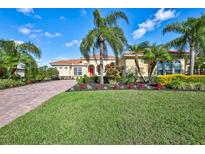 Spanish style home with red door, paver driveway & lush landscaping at 17113 1St E Dr, Bradenton, FL 34212