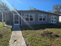 Newly renovated house exterior with gray siding and a walkway at 21459 Olean Blvd, Port Charlotte, FL 33952
