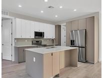 Modern kitchen featuring stainless steel appliances, an island, and sleek cabinetry at 2258 Margaret Ln, North Port, FL 34286