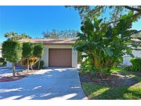 Front view of charming condo with attached garage and lush landscaping at 2915 Oak Ln, Bradenton, FL 34209