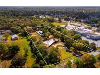 Aerial view of a single Gathering home on a large lot with mature trees at 3825 Sarasota Golf Club Blvd, Sarasota, FL 34240