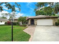 Inviting home with stone facade, landscaped lawn, and a two-car garage at 4035 Keats Dr, Sarasota, FL 34241