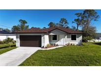 Newly constructed home with a brown roof and a 2-car garage at 5210 Fries Ave, North Port, FL 34288