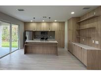 Open concept kitchen with island and stainless steel appliances at 5274 Neon Ave, North Port, FL 34291