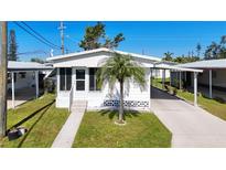 White single-wide manufactured home with carport and palm tree at 615 50Th Avenue W Dr, Bradenton, FL 34207