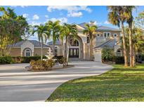Stunning two-story home with a circular driveway, fountain, and meticulously landscaped front yard at 6779 Ashley Ct, Sarasota, FL 34241