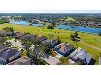 Aerial view of a house on a golf course community with a lake nearby at 10643 Old Grove Cir, Bradenton, FL 34212